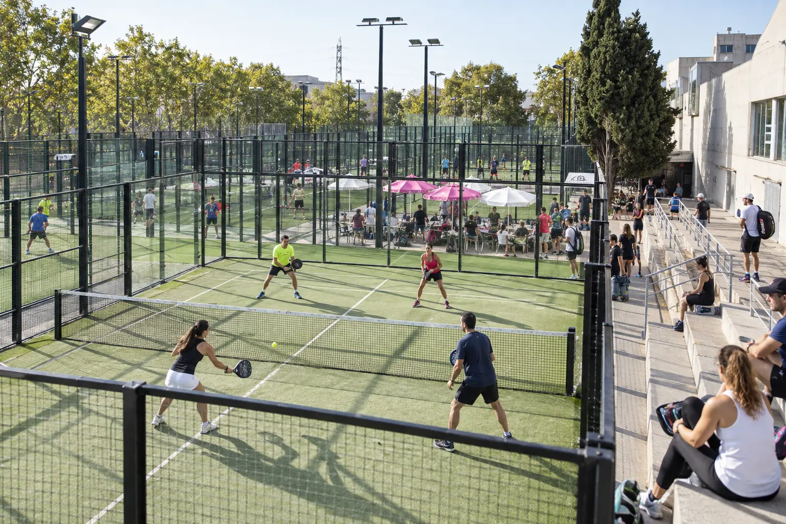 Pistes de pàdel amb participants jugant a l'aire lliure